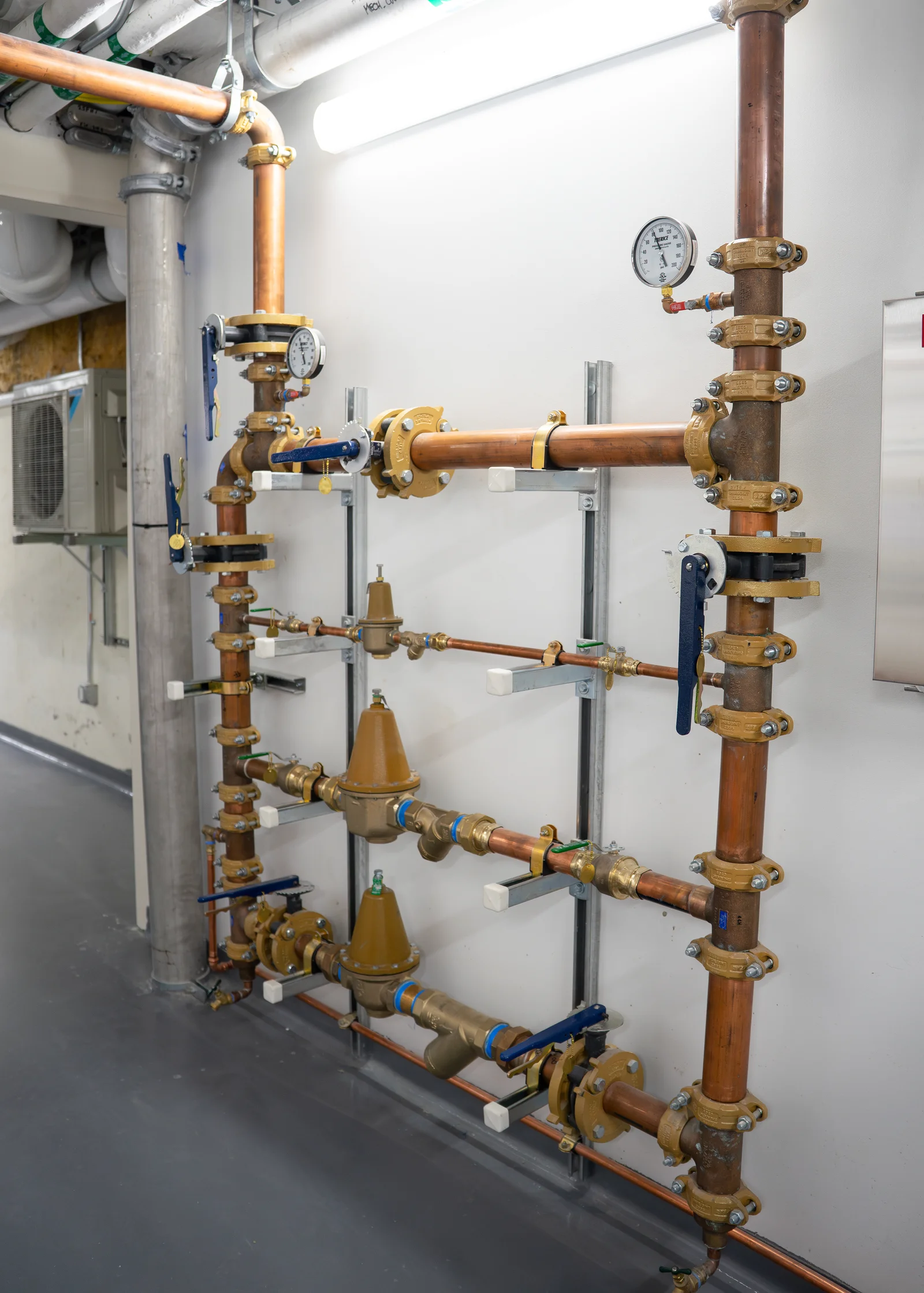 Copper water piping assembly with valves and backflow preventers in the lab's mechanical room