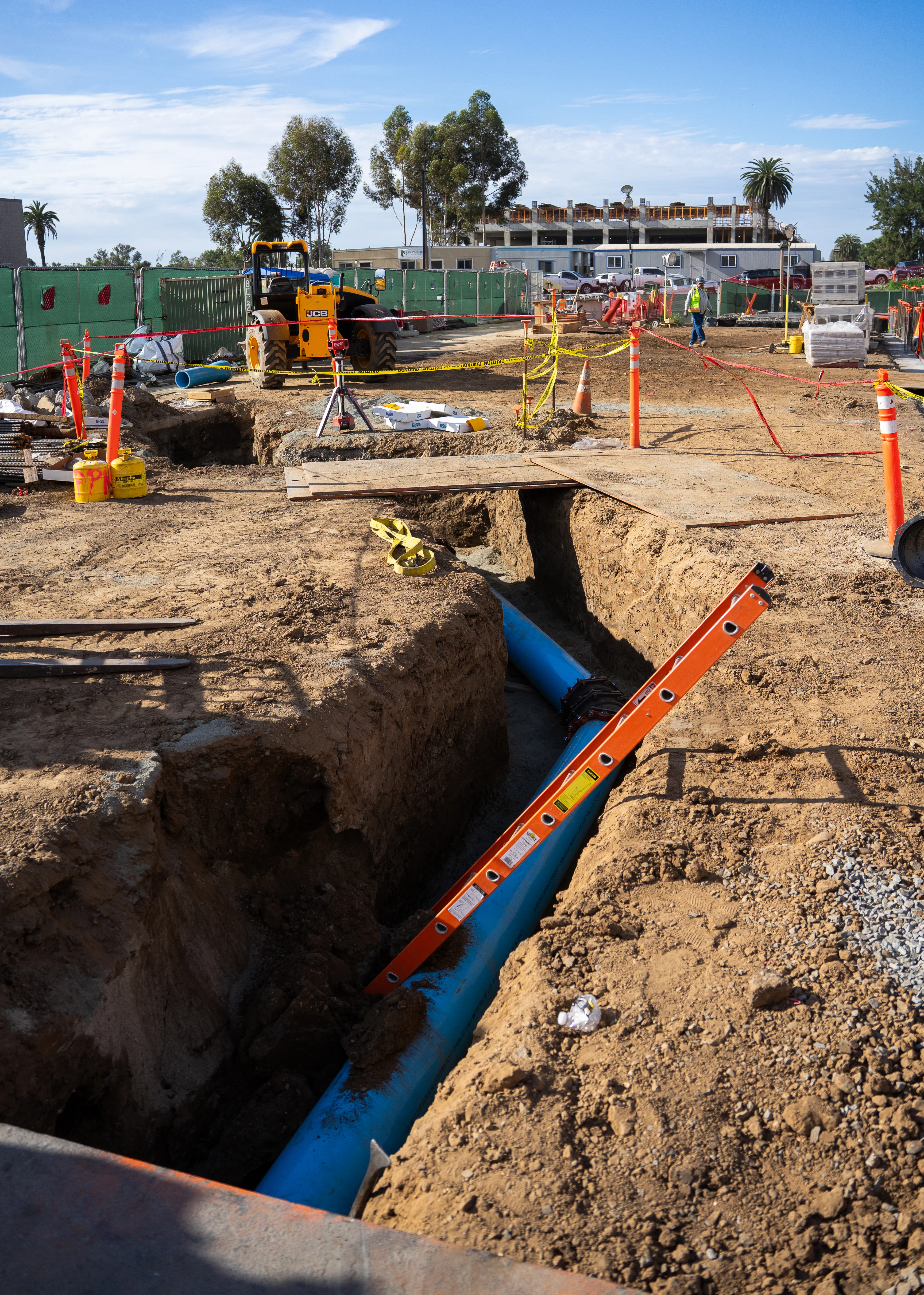 Underground utility piping being installed in an open trench at the VA Medical Center site